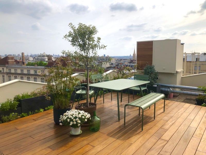 Nature Bois Concept – Terrasse d’une cliente en Garapa sur le toit d’un immeuble, avec disposition de plantes en pot